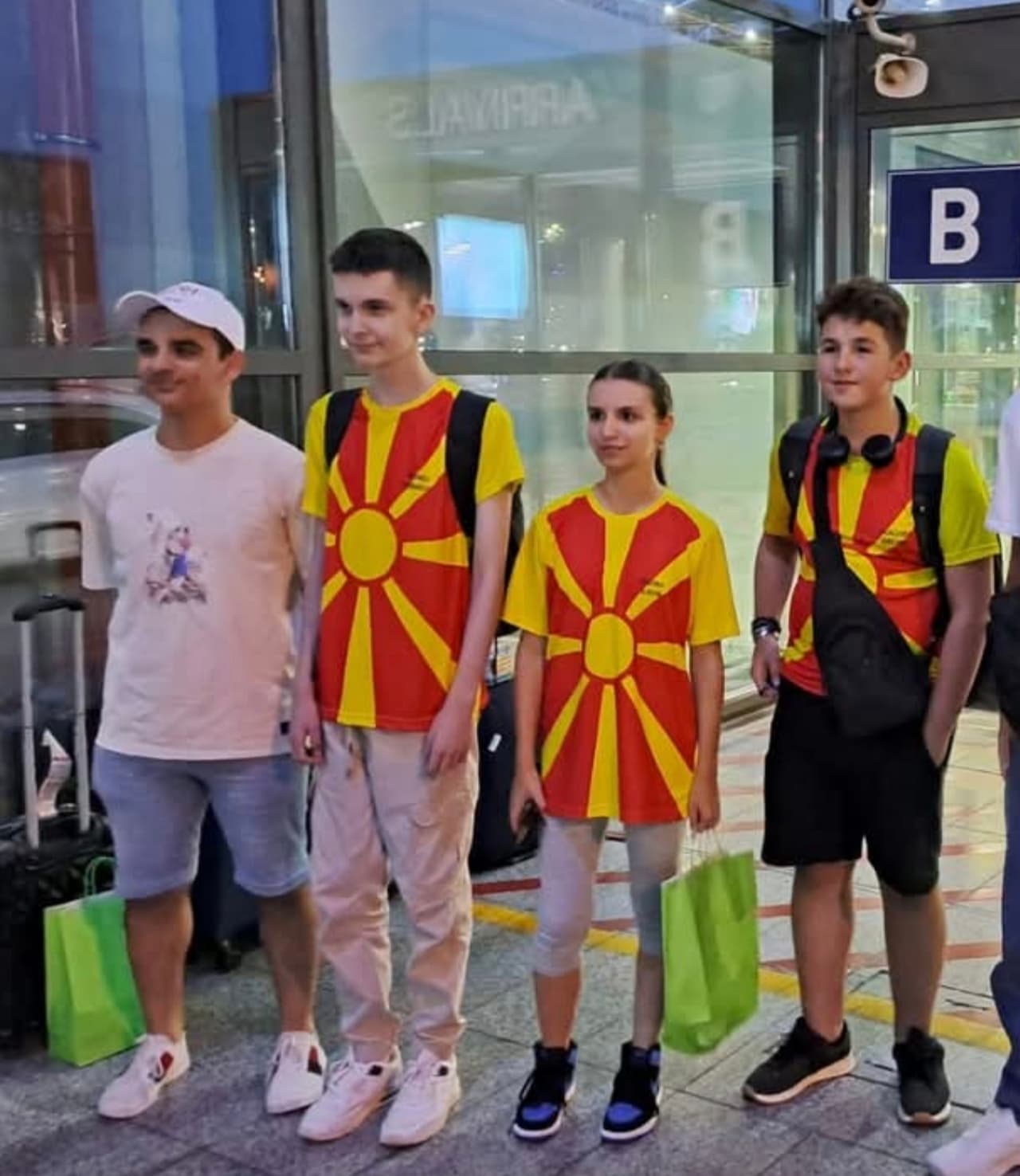 Екипата во дресови со македонското знаме позира на аеродром.
